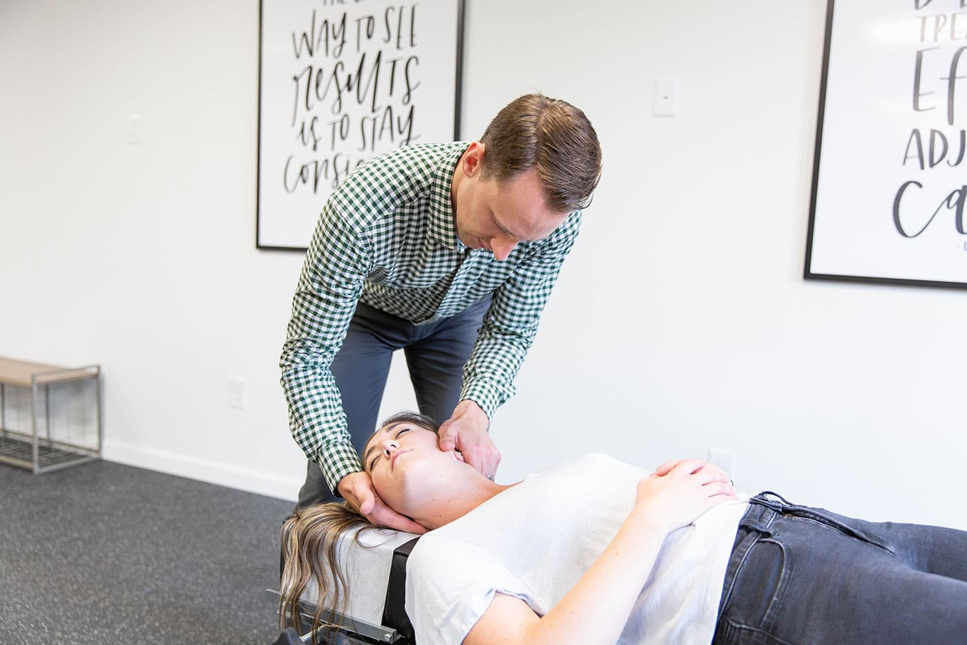chiropractor providing neck pain treatment to young woman